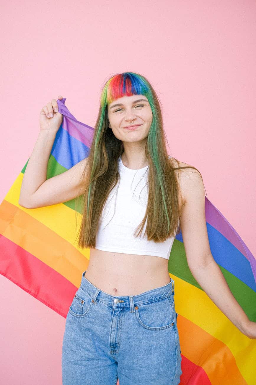 a smiling woman with rainbow bangs