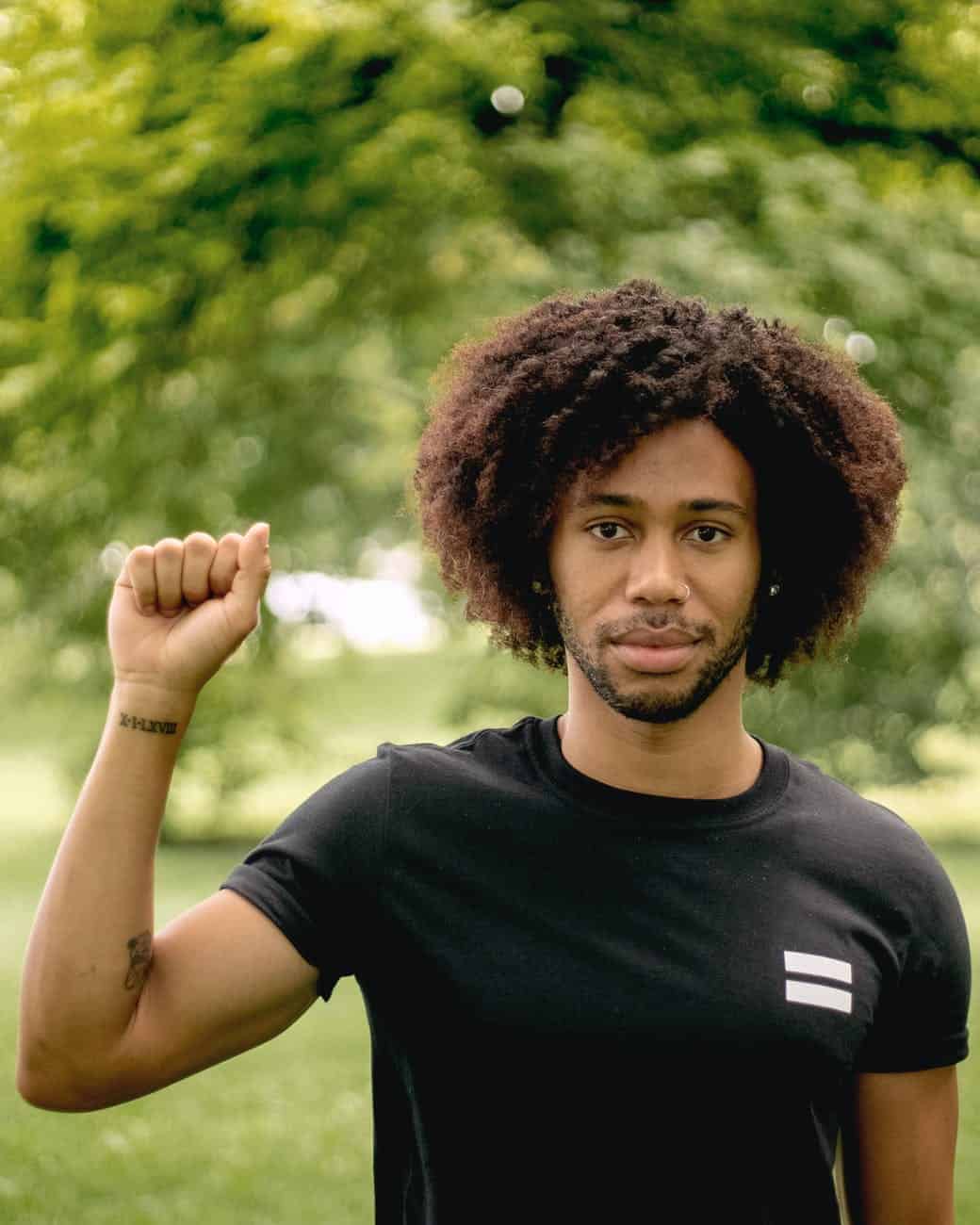 a man in a black shirt raising his fist in solidarity