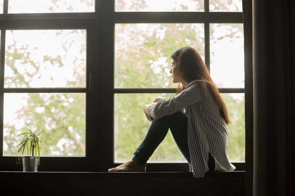 a woman sitting looking out a window