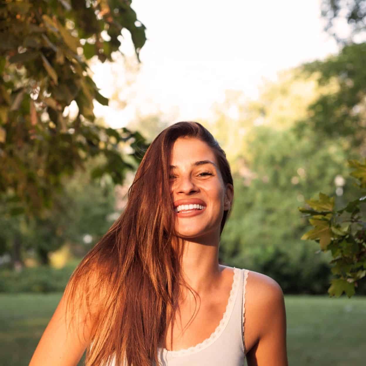 a woman smiling while in a park trauma therapy