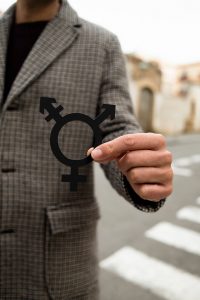 Image of a gender symbol being help up by a person in a coat. Have you been wondering of there is a 