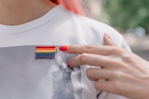 Image of a person wearing a beaded rainbow flag pin. Have you been searching for an "LGBTQ friendly therapist near me" in North Carolina? We provide LGBTQIA+ therapy in Asheville, North Carolina with LGBTQ+ affirming therapists. Call today!