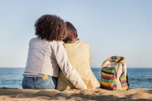 Image of a lesbian couple sitting on the beach together near Wilmington, NC. We strive to give you access to LGBTQ friendly therapists in North Carolina? If you are in Asheville, NC we have LGBTQ affirming therapists. Get support from an LGBTQIA+ theerapist in LGBTQIA+ therapy in North Carolina. Whther you are in Charlotte, Raleigh, Asheville or Wilmington we can help you!