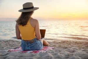 Image of a woman in a yellow tank top sitting on the beach. Our online therapists offer anxiety treatment and BIPOC mental health resources in North Carolina. You can get access to any or all of these with our online therapy. Reach out to us today!