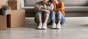 Image of an upset couple sitting next to each other on the floor showing who a couples therapist could help through marriage counseling in North Carolina. Whether in Asheville or Wilmington or in between if your partnership is suffering then a marriage counselor can help with couples therapy in North Carolina.