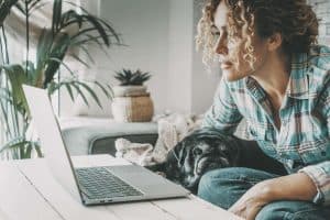 Imge of a woman sitting on the couch with her dog for an virtual therapy appointment. Showing that you can meet with an online therapist in North Carolina from wherever is convenient for you. Whether at home or at work or on vacation you can benefit from online therapy.