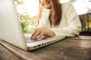 Image of a woman in a white seater talking with an online therapist on her laptop. Online therapy lets you connect with specialists throughout North Carolina. Plus scheduling an online therapy appointment is more convenient than in person counseling.